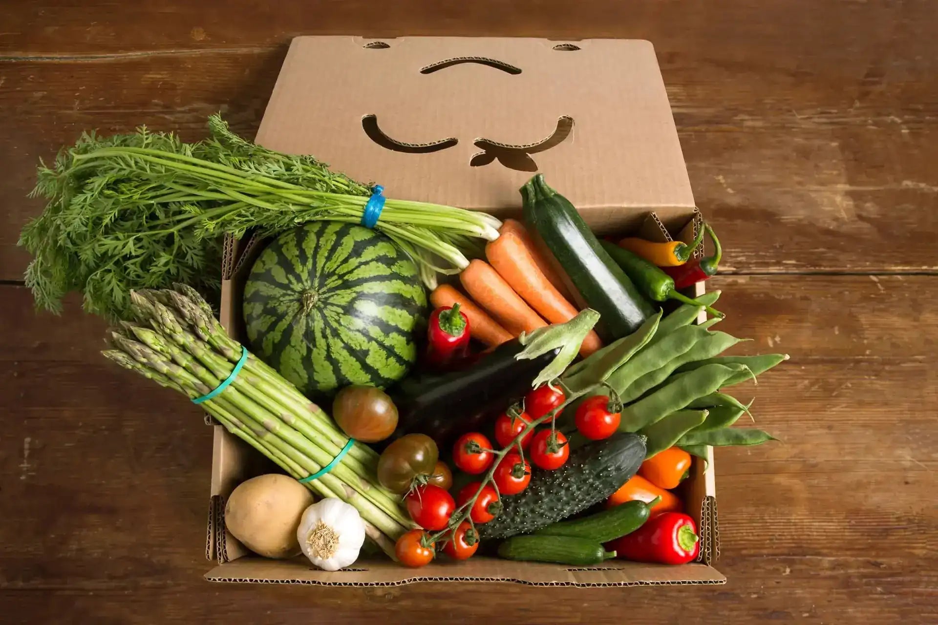 Caja de frutas y verduras variadas, vista cenital.
